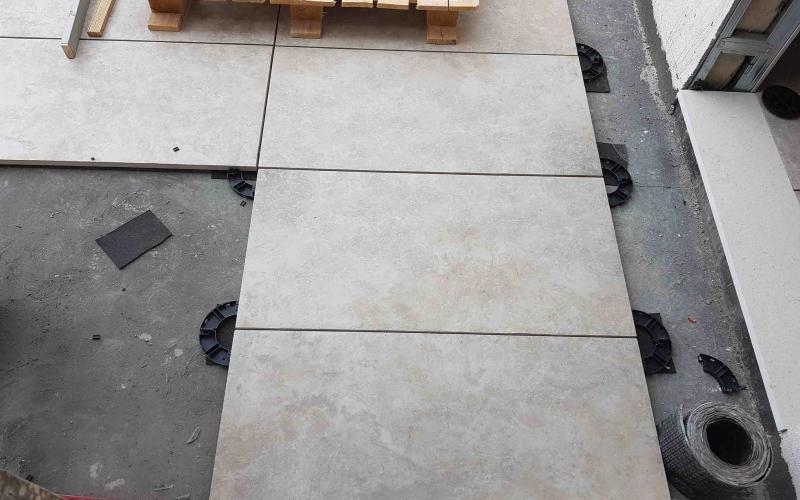 Installation of thick floating tiles on outdoor terrace 