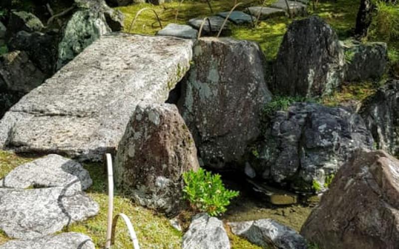 Pietre sul muschio e ponticello in un giardino giapponese