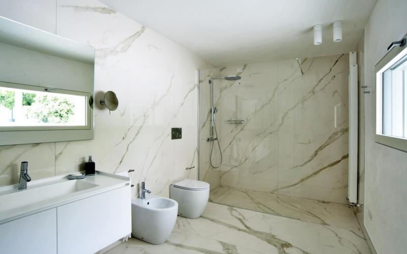 Walk in shower in a bathroom with large slabs tiles