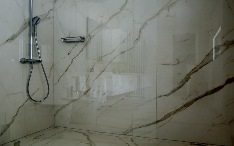 Walk in shower in a bathroom with large slabs tiles