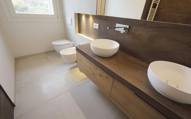 Attic bathroom with bathtub, detail of the basins and stoneware flooring