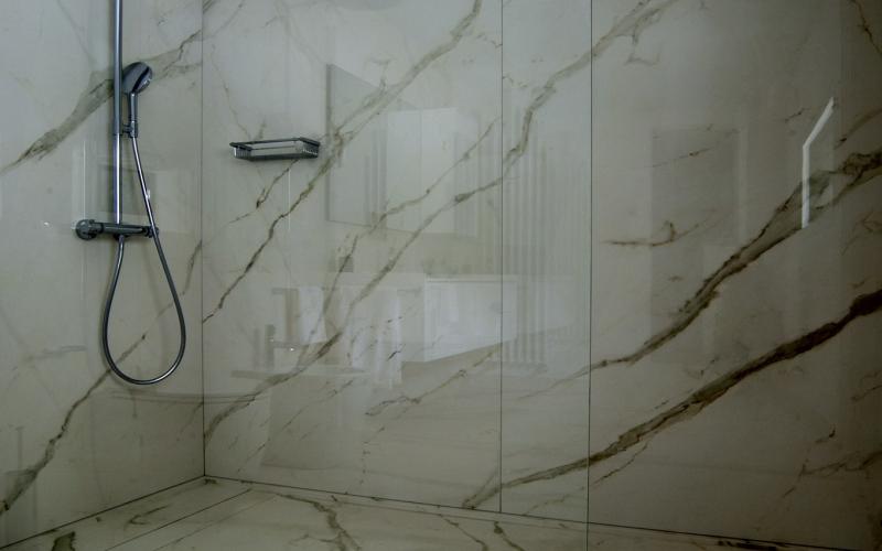 Walk-in shower enclosure with fixed glass