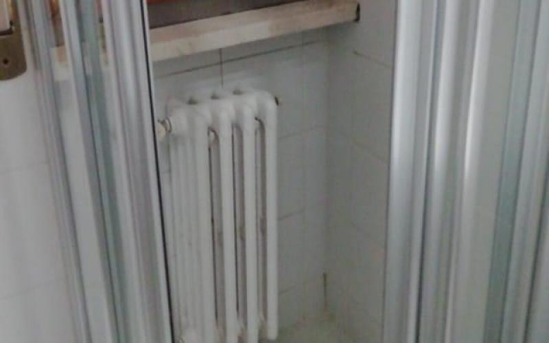 Un termosifone collocato dentro ad un box doccia