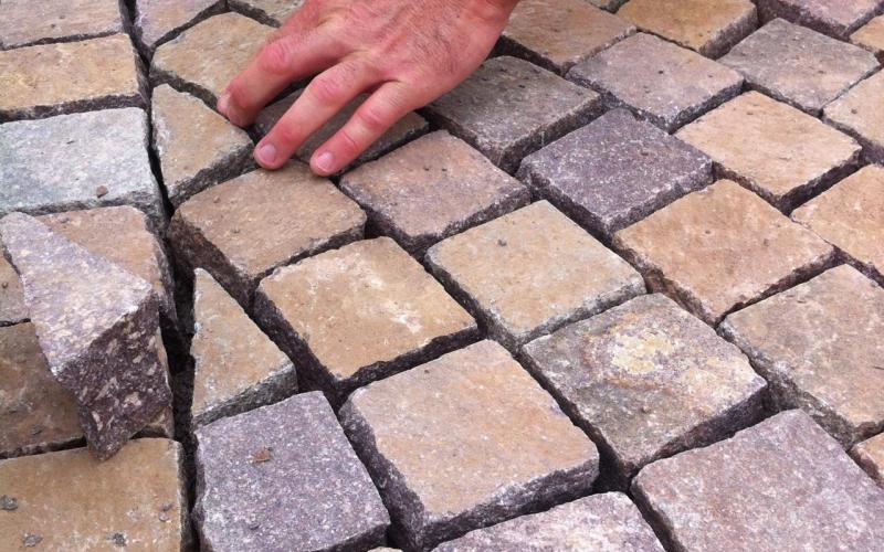 Laying porphyry cubes in an outdoor paving in the garden in Vicenza