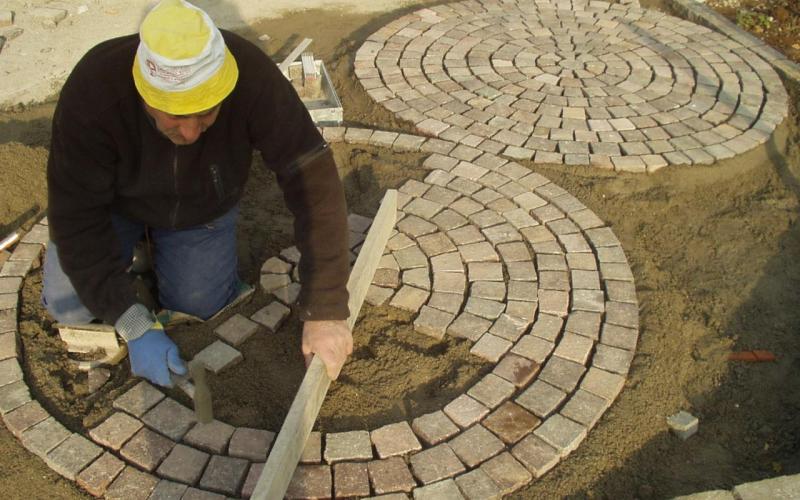 Laying porphyry cube paving in a garden in Vicenza