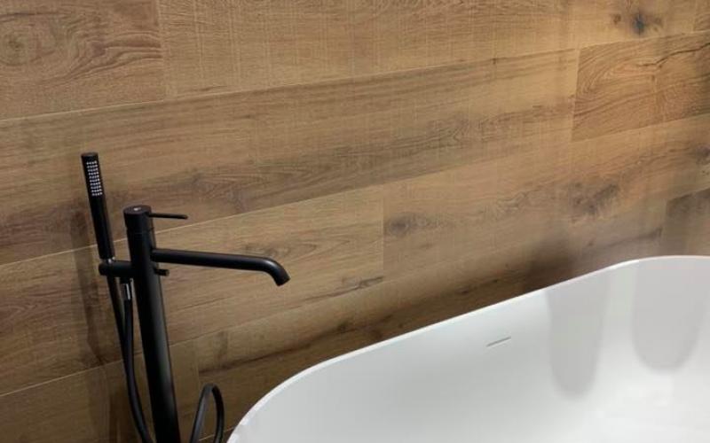 Una parete in grès effetto legno come sfondo per una vasca stand alone