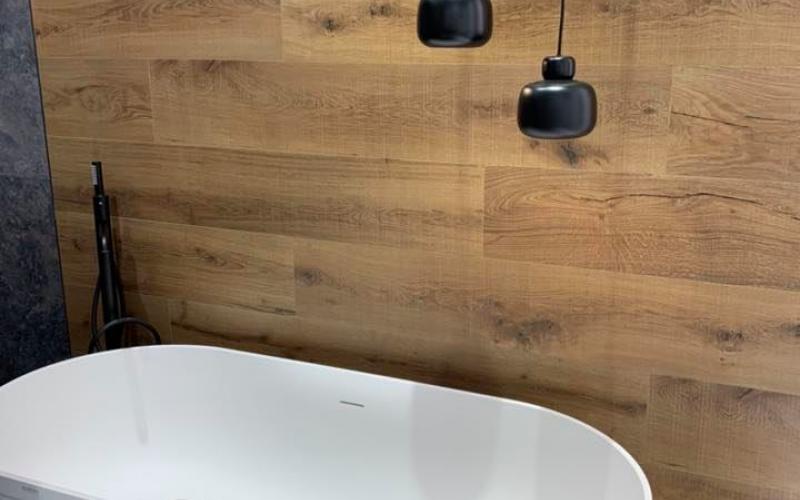 Una parete in grès effetto legno come sfondo per una vasca stand alone