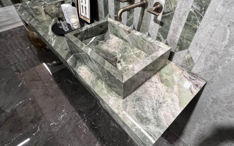 Grandi lastre in grès effetto marmo verde in un bagno