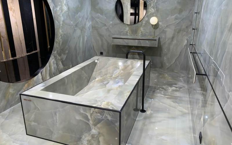 Vista della vasca, del pavimento e del rivestimento di questo bagno completamente realizzato in gres porcellanato levigato lucido