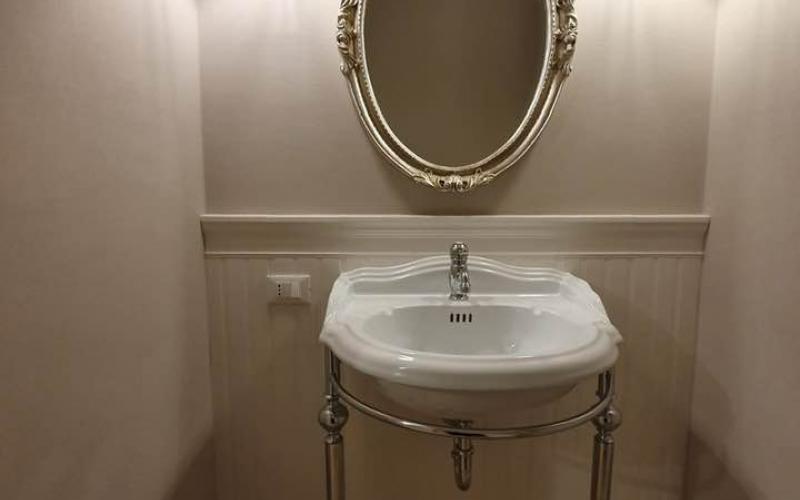 Illuminazione del bagno in stile inglese con applique ai lati dello specchio 