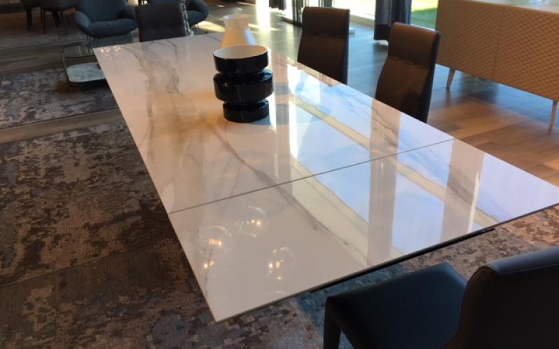 E' di colore bianco venato la grande lastra di gres effetto marmo utilizzata per realizzare un tavolo per la zona pranzo di questa casa