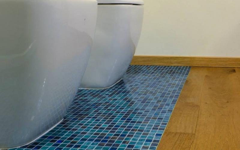 bagno con mosaico azzurro a pavimento abbinato al legno