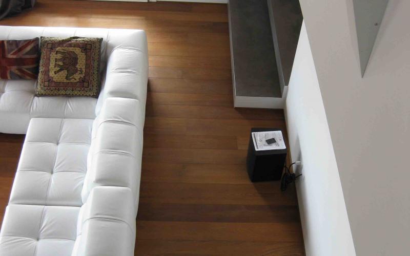 Pavimento in legno nel salone visto dal soppalco con il grande divano