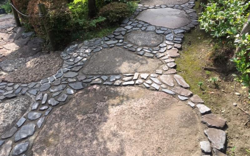 Vialetto in giardino giapponese: ciottoli tondi neri e grandi pietre
