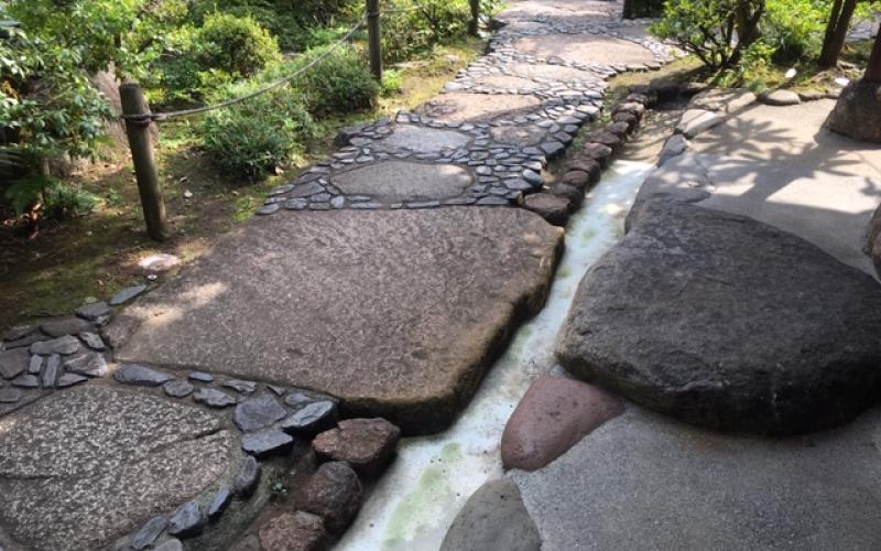 Vialetto in giardino giapponese: ciottoli tondi neri e grandi pietre