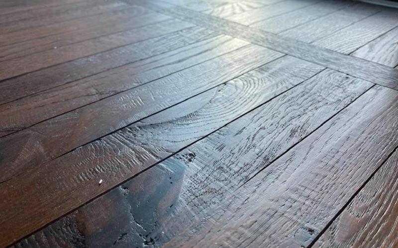 La superficie lavorata artigianalmente del pavimento in legno