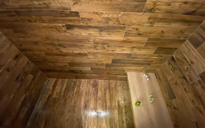 Piatto doccia e pareti rivestite con grès effetto legno rustico