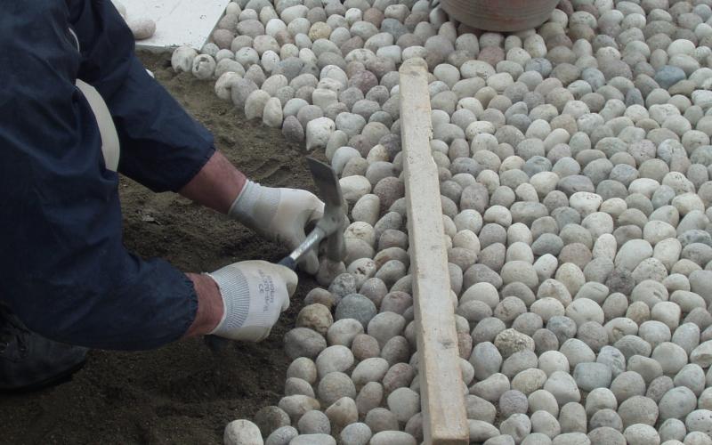 Laying outdoor pebble stone flooring