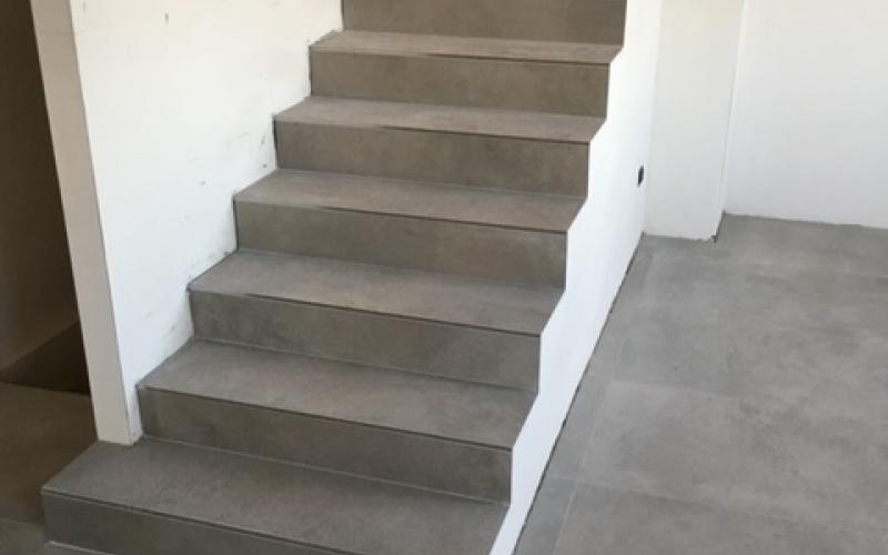 La rampa di scale realizzata in piastrelle di grès effetto cemento con gradini di tipo simple