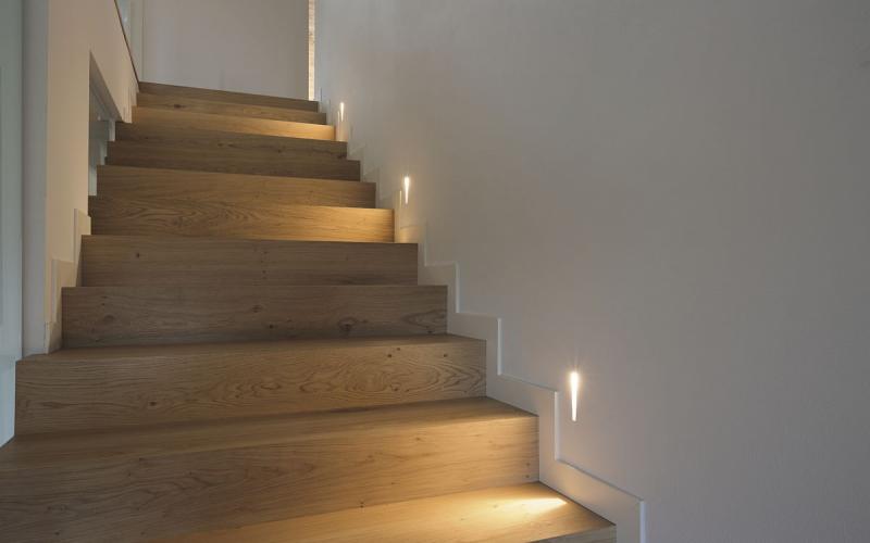 scalini in legno di rovere illuminati da segnapassi a muro