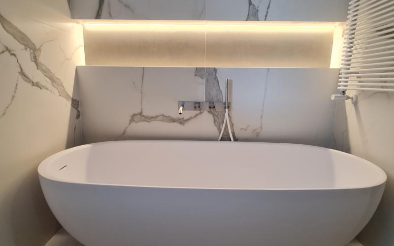 vasca freestanding nicchia illuminata grandi lastre effetto marmo
