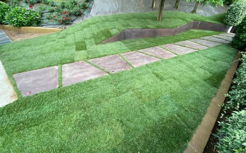Vialetto in giardino con piastrelle effetto corten nell'erba