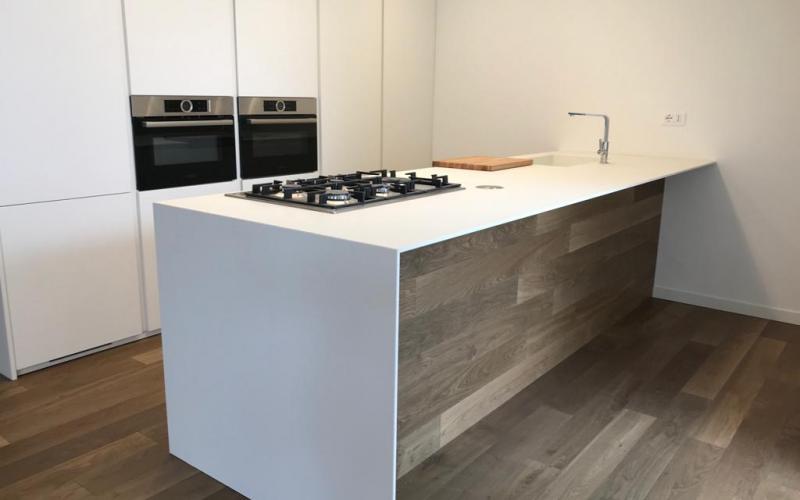 Vicenza: white kitchen with island. The floor rises and wraps around the island